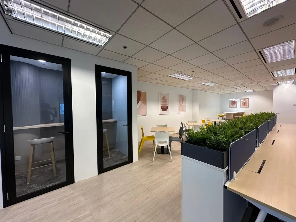 Open office with phone booths, planter dividers and bench workstations