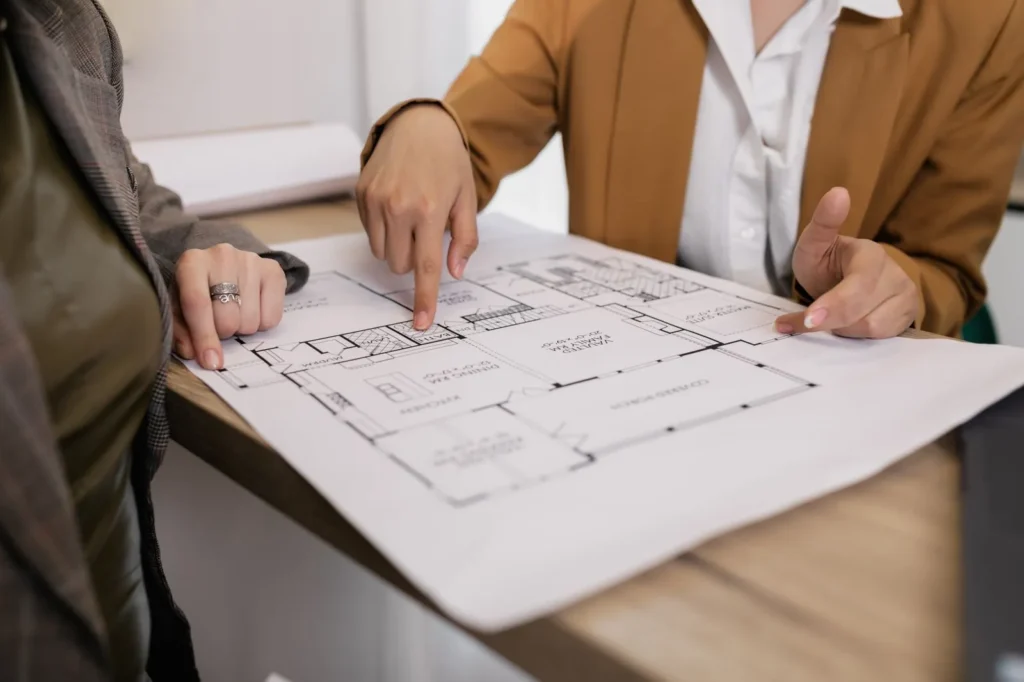 Designer pointing at an office floor plan