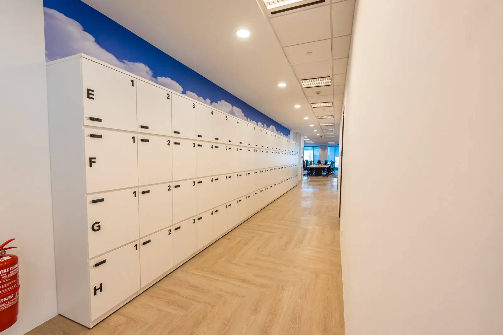 A long corridor of staff lockers with a sky mural, built by CTN