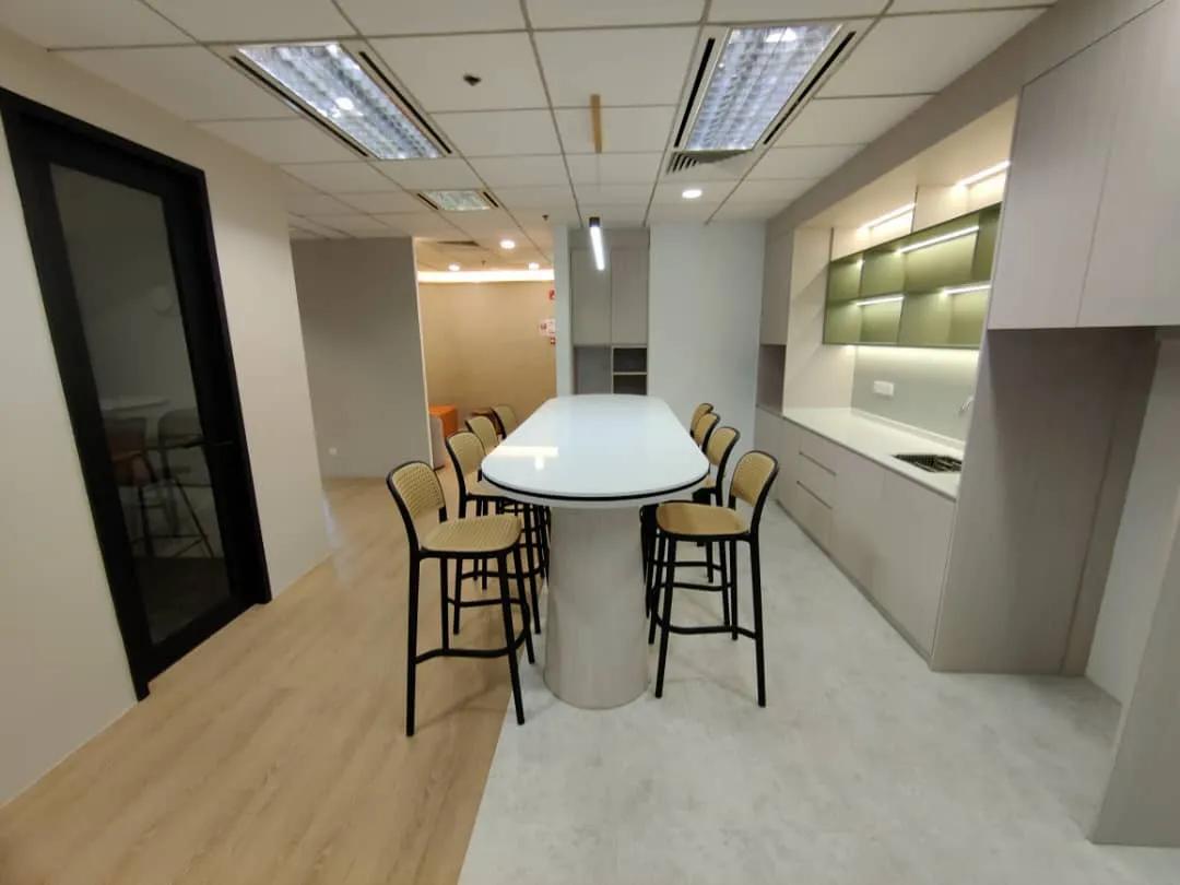 An office pantry with a bar-height island, stools and lit shelving, fitted out by CTN